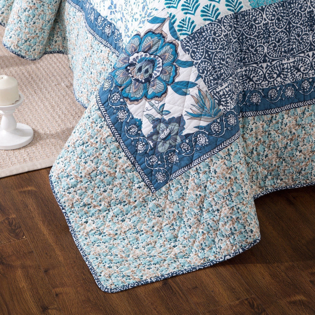 Blue floral quilt corner with stitched edge trim and patterned patchwork panels