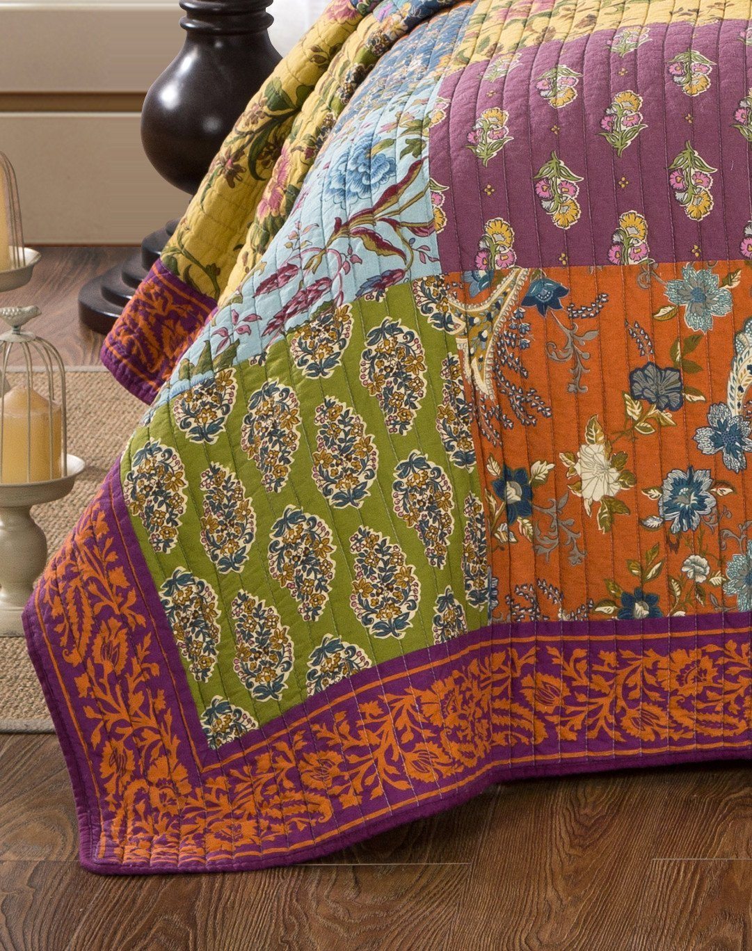 Quilted bedspread detail with orange border and multicolor floral patchwork panels
