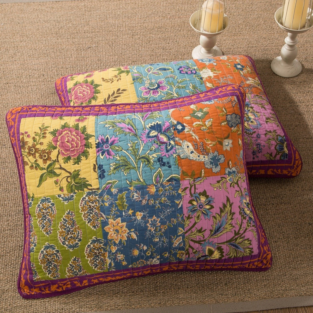 Folded quilt and matching pillow with colorful floral patchwork and purple edging