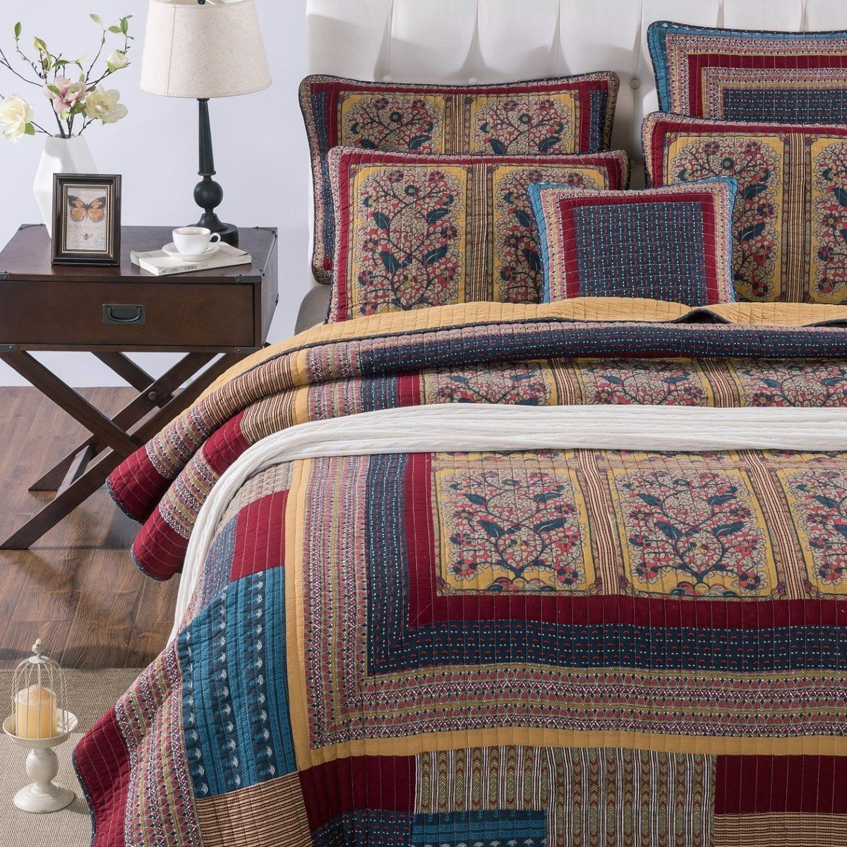 Decorative patchwork quilt bedspread with framed medallions in blue, red, and tan