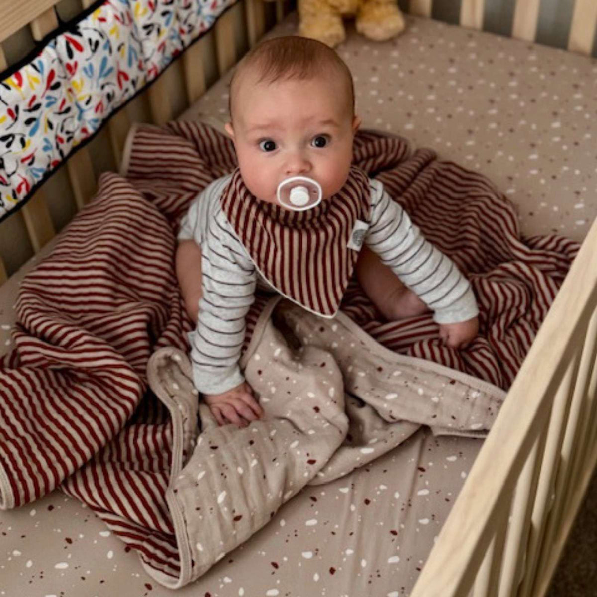 Butterfly quilt draped in a baby play space, light fabric with small motif prints