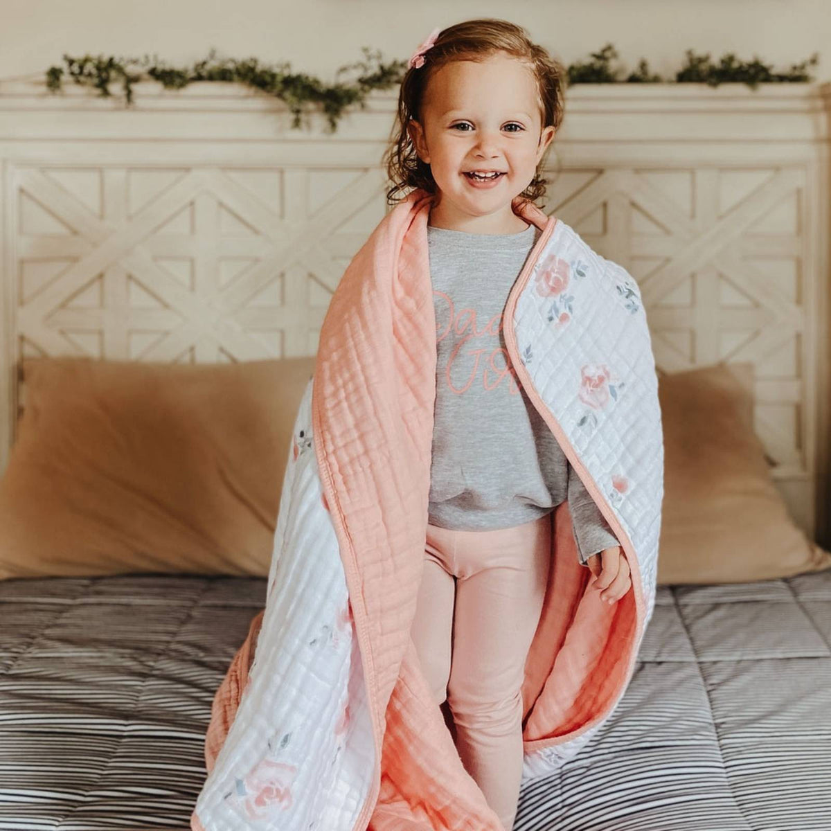 Pastel checker quilt draped over child’s shoulders, soft muslin fabric
