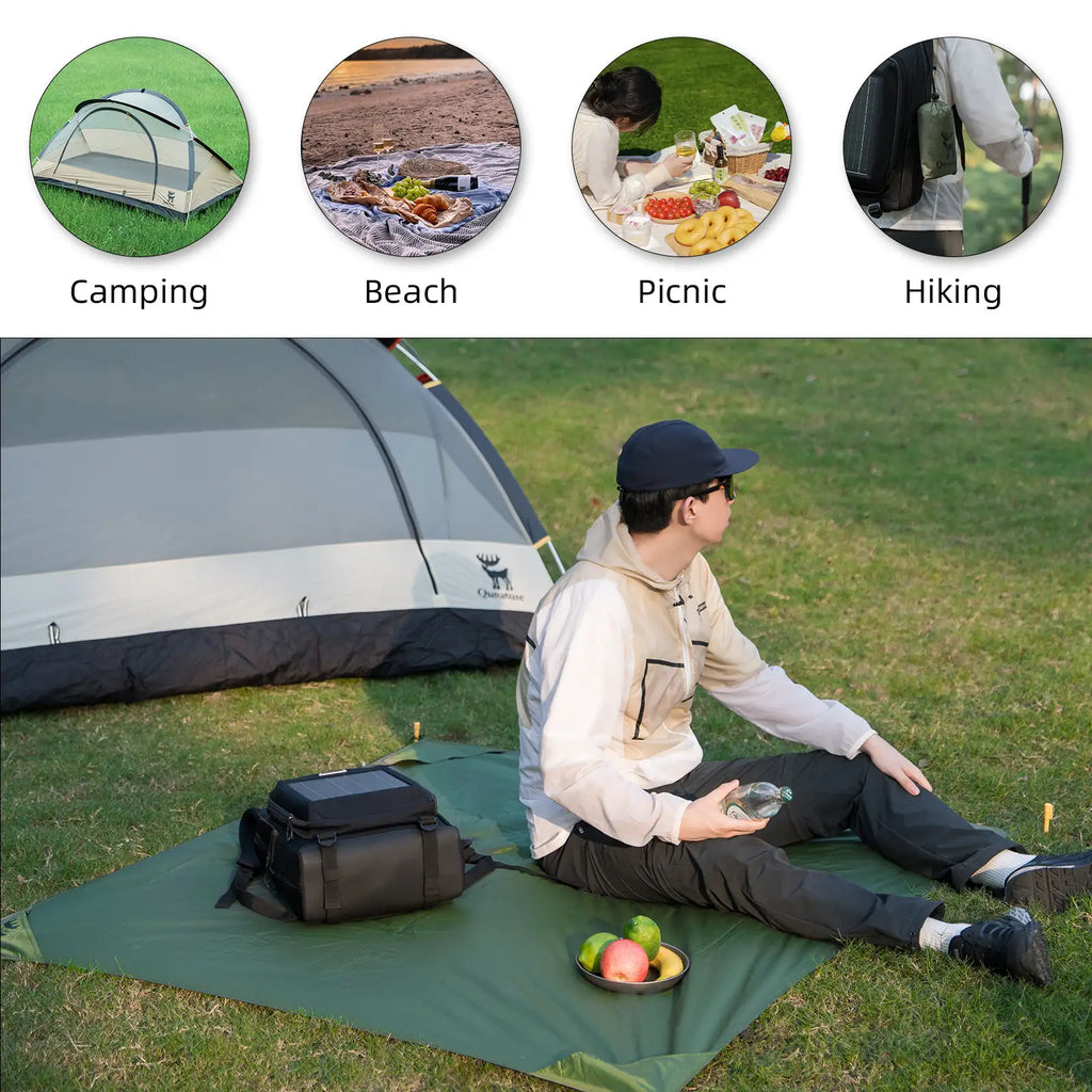 Green picnic mat on grass for camping seating with person and side bag