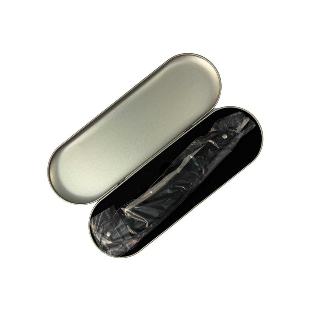 Opened silver razor case with black interior and wrapped razor