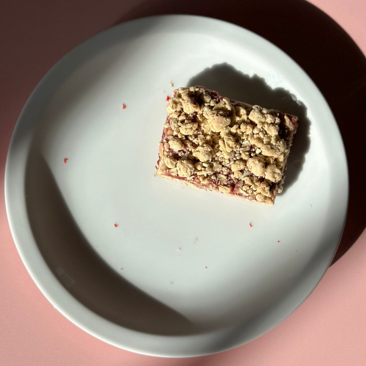 Raspberry oat bar on white plate