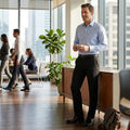 Men's black stretch slim-fit pants, front view standing in an office setting