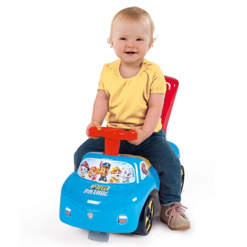 Blue Paw Patrol ride-on pusher car with red handle and yellow seat, toddler sitting on top.
