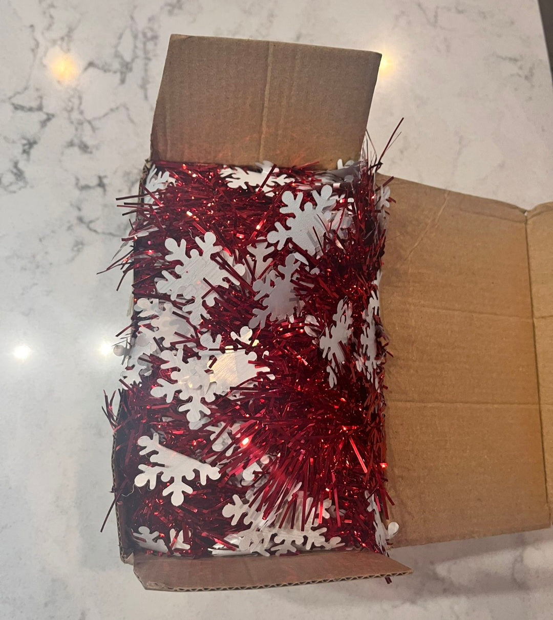 Red and white snowflake tinsel garland bundle in a retail box