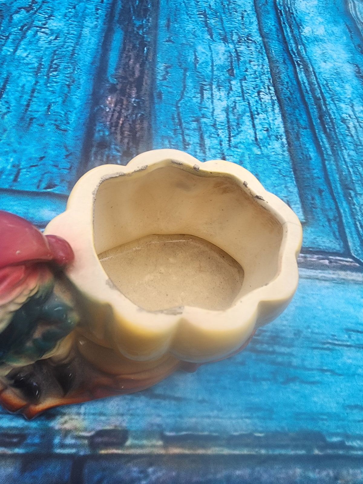 Yellow ceramic planter with gnome figure and scalloped bowl rim, side view