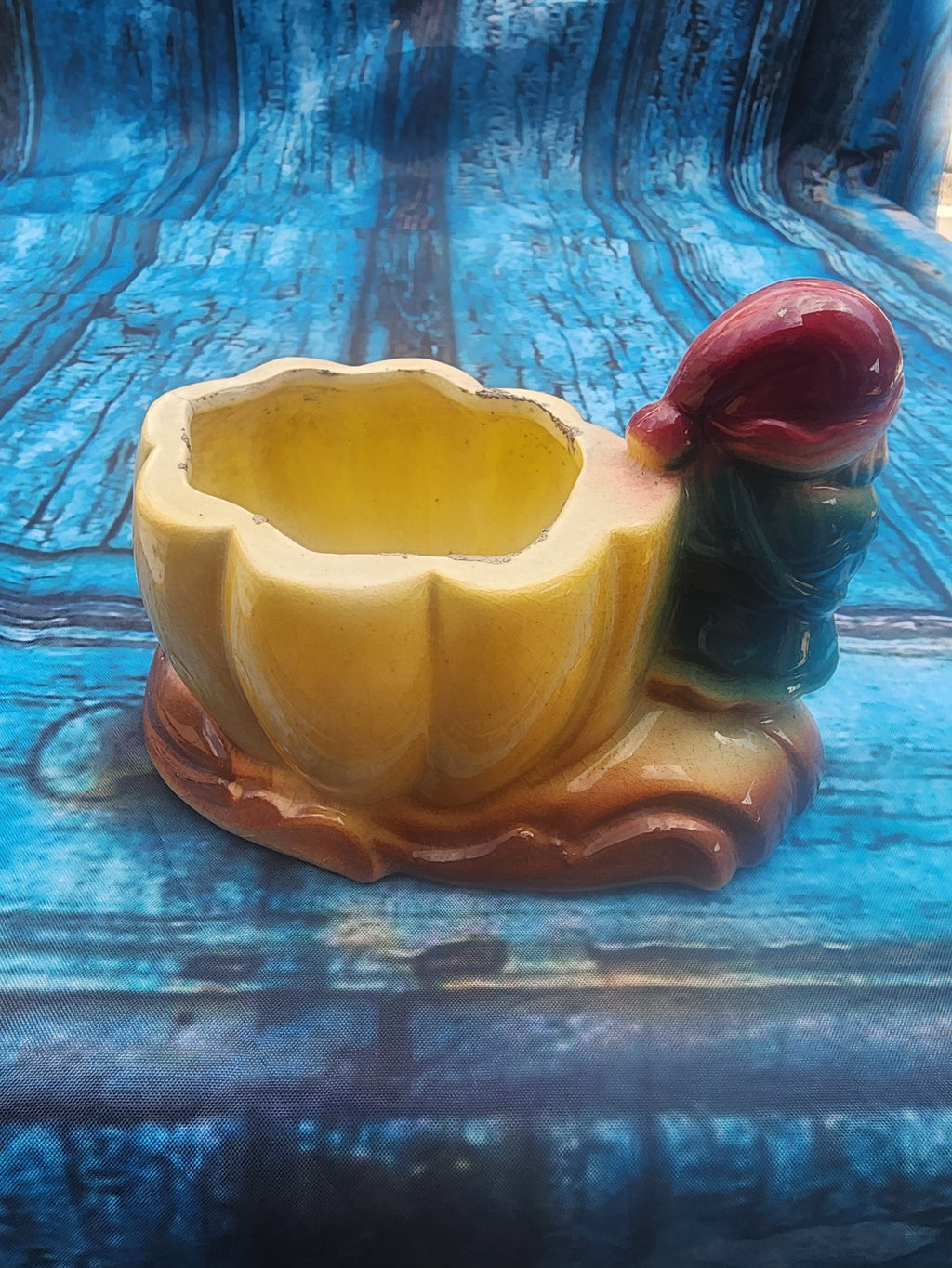 Yellow ceramic gnome pumpkin planter with curved base and red-capped gnome head