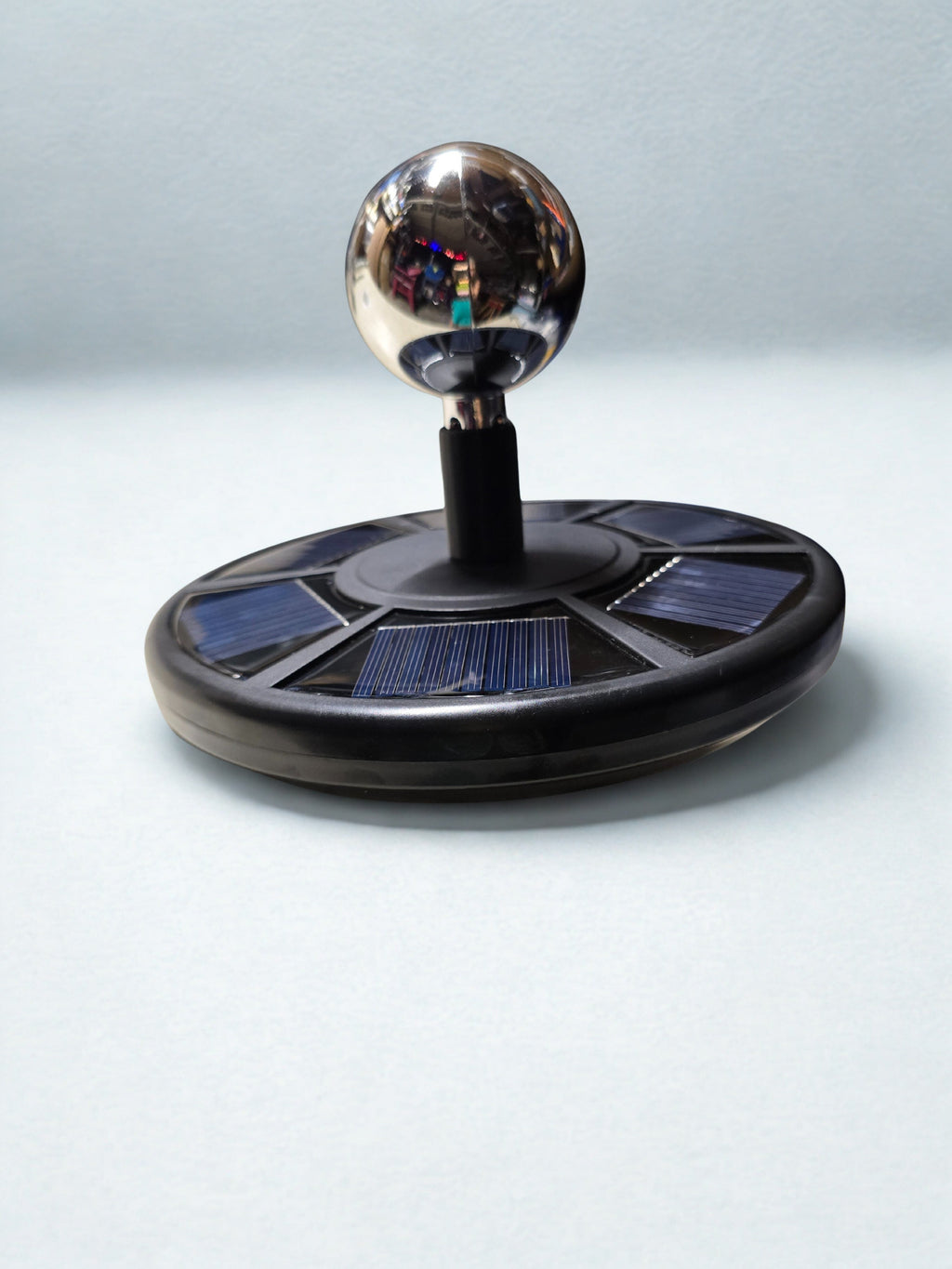 Solar flag light with round solar panel base and chrome ball adapter mounted on top