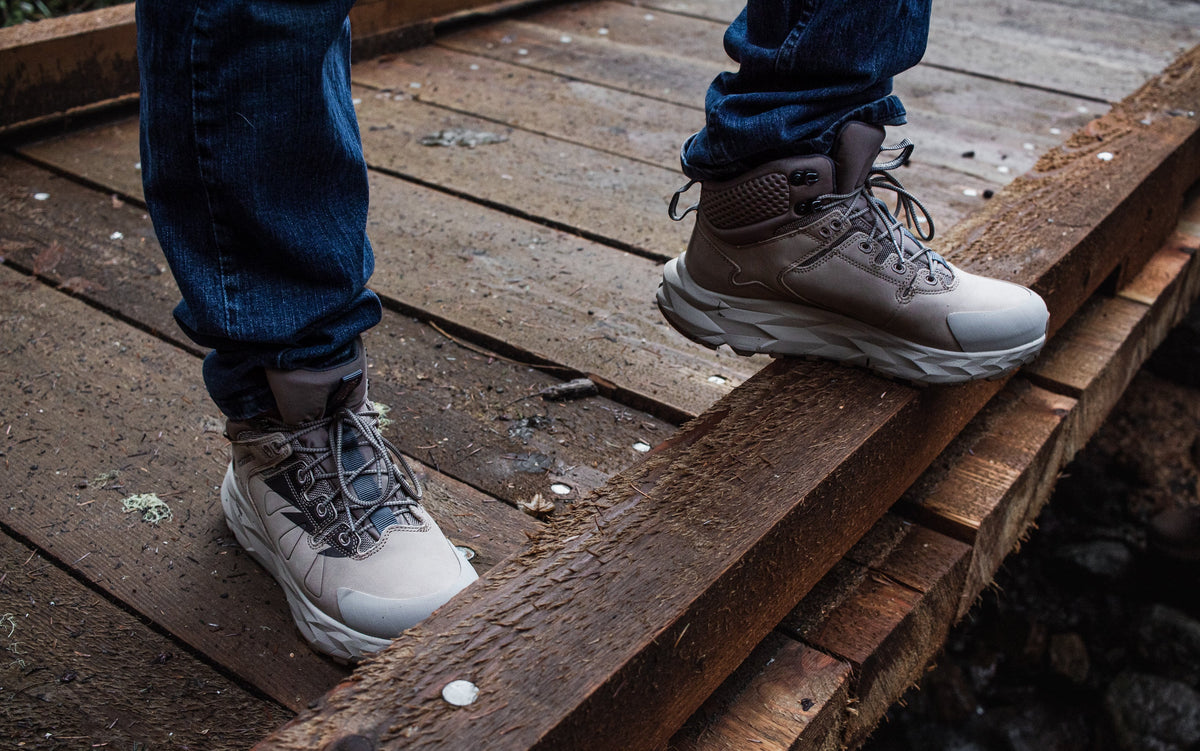 Two tan waterproof hiking boots with lace-up closure and grippy outsole tread