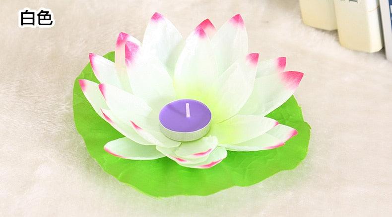 White lotus LED floating candle with green base and lit purple center