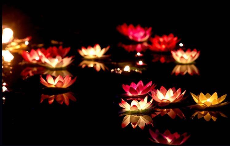 Floating lotus LED candles in red and gold tones with glowing tea-light centers