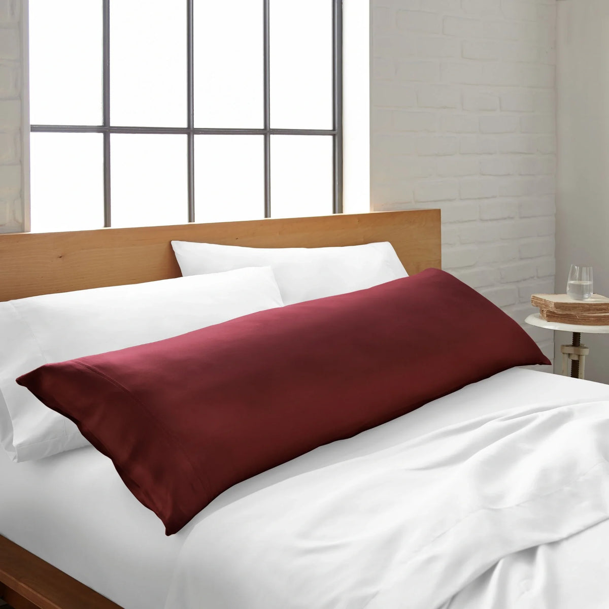 Burgundy red body pillowcase with smooth fabric on bed