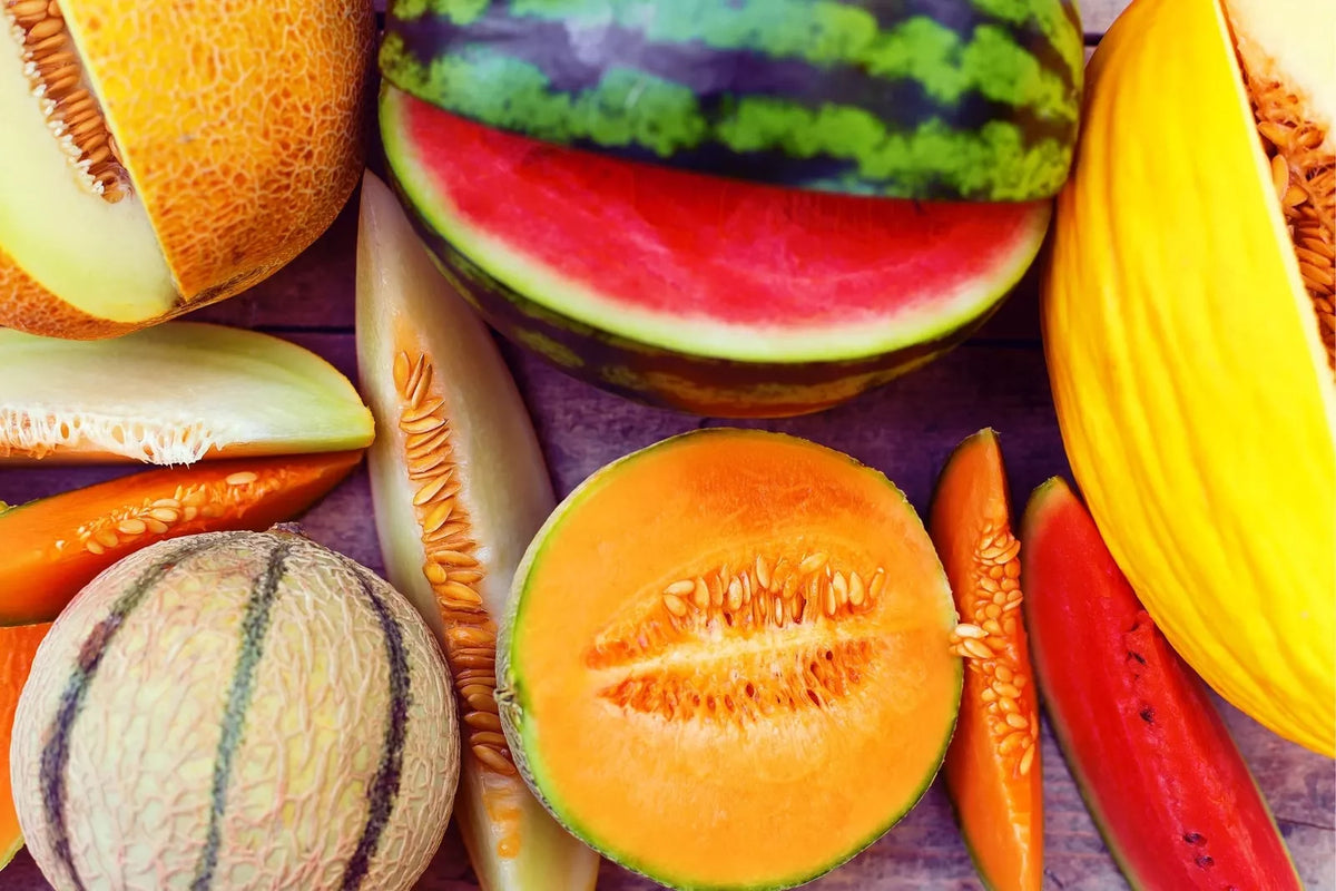 Garden melon seeds mix with sliced orange and red melons and yellow fruit halves