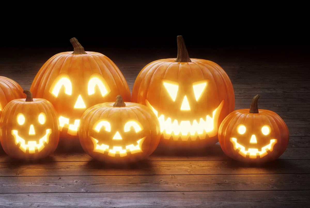 Orange jack-o-lantern pumpkins with carved faces, jack o' lantern style