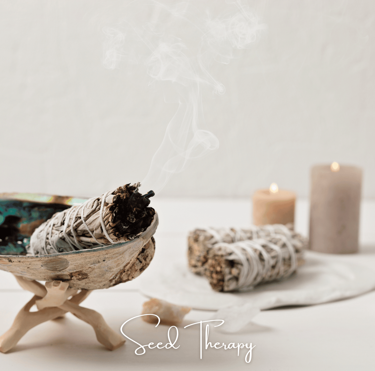 Dried white sage bundle with light smoke, resting on wood