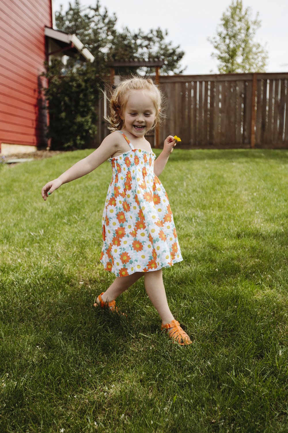 Orange kids sandals on a child running outdoors, hook-and-loop open-toe design