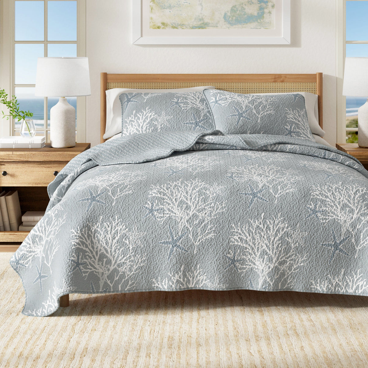 Blue quilt set with starfish and coral pattern, on-bed with two matching pillow shams.