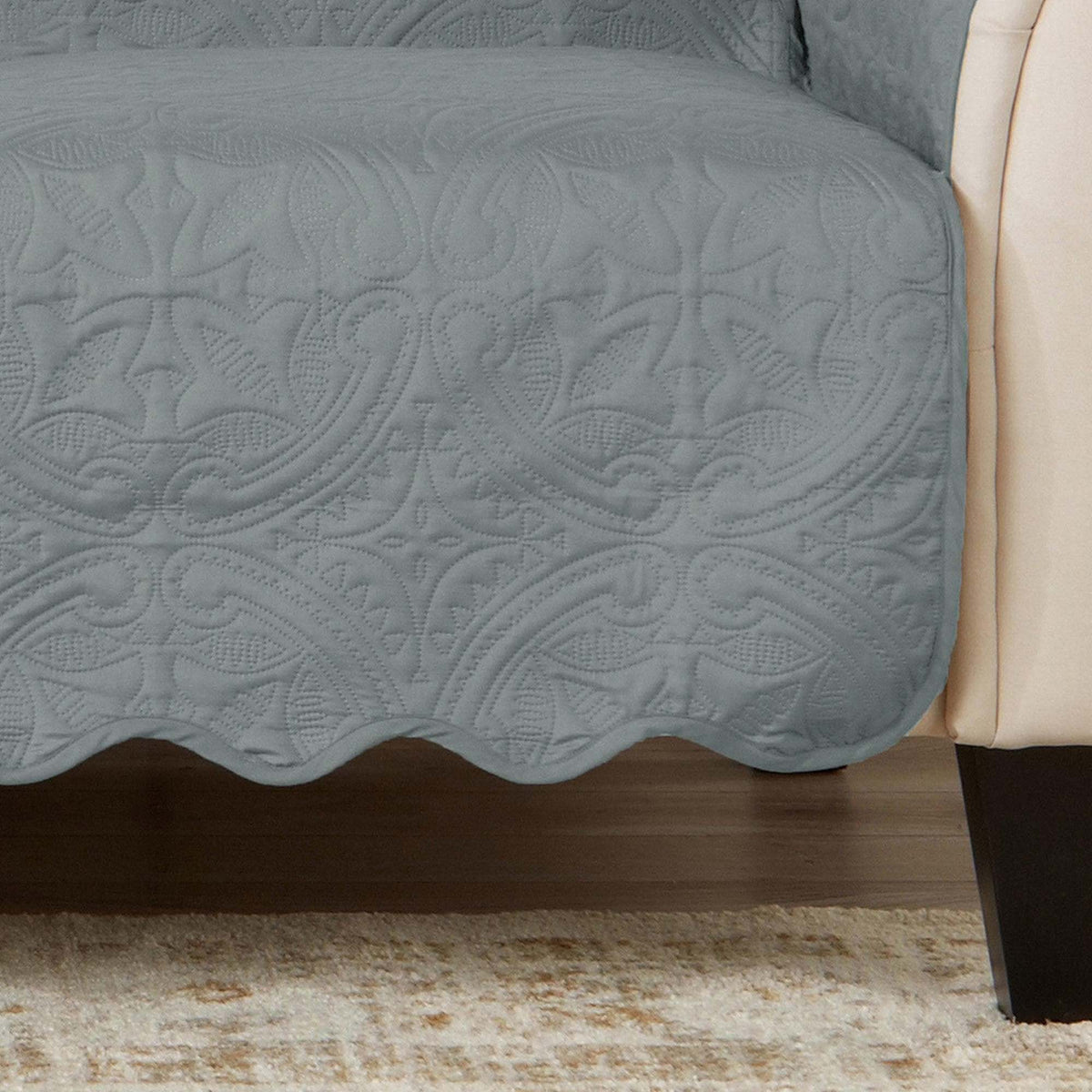 Blue-gray furniture protector fabric with embossed quilted floral pattern and scalloped edge