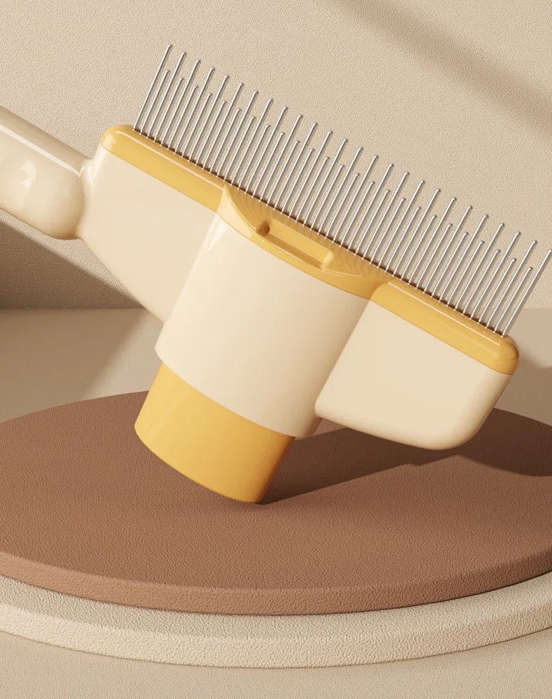 Self-cleaning pet comb with stainless steel teeth on yellow-and-beige handle
