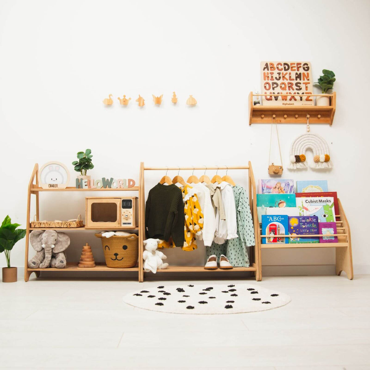 Light wood kids playroom organizer with hanging rail, shelves, and toy storage units