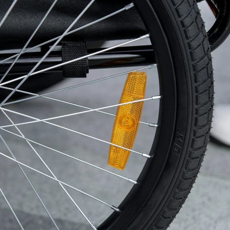 Black dog bike trailer wheel with amber reflector and metal spokes