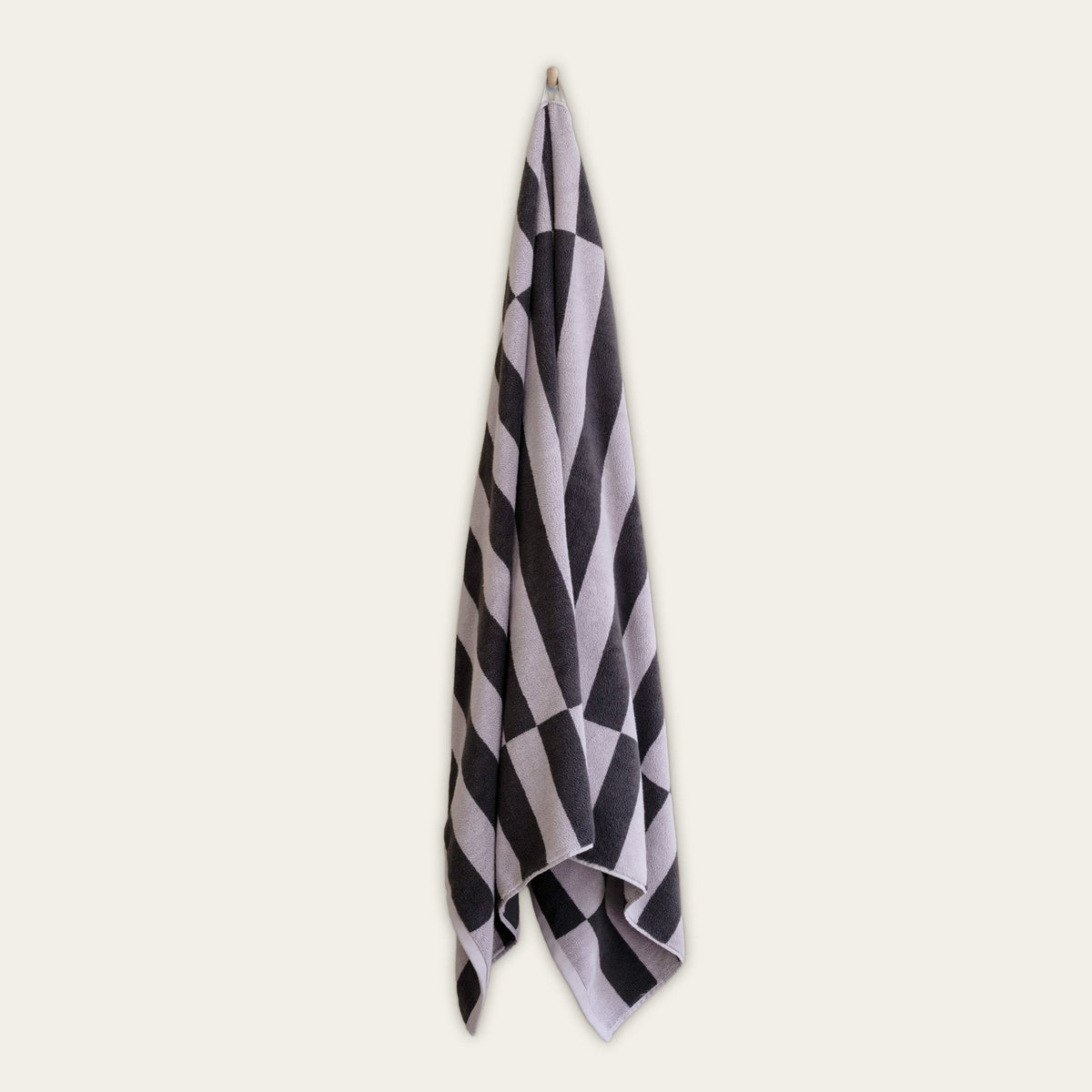 Australian cotton towel, lilac-gray with black-and-white check pattern, folded and hanging