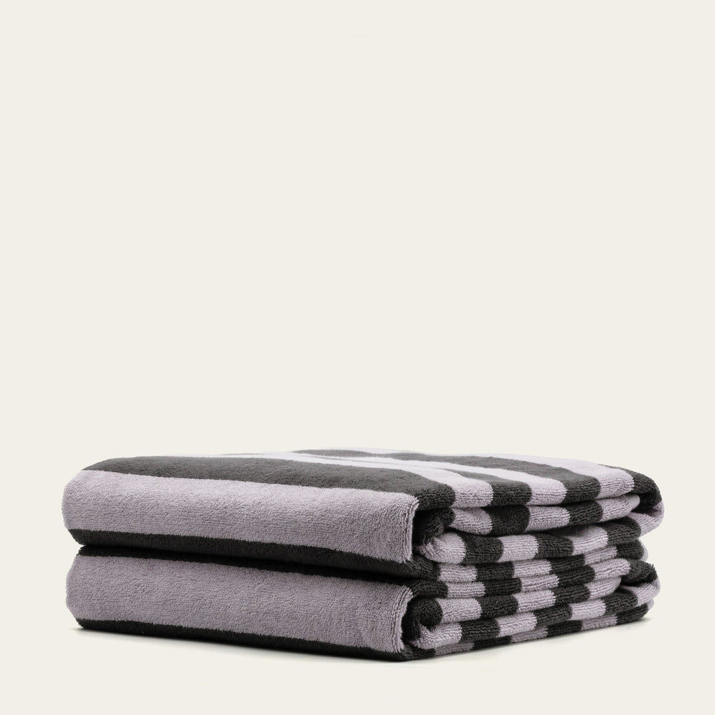Australian cotton towel stack, lilac-gray with black-and-white striped ends, plush terry