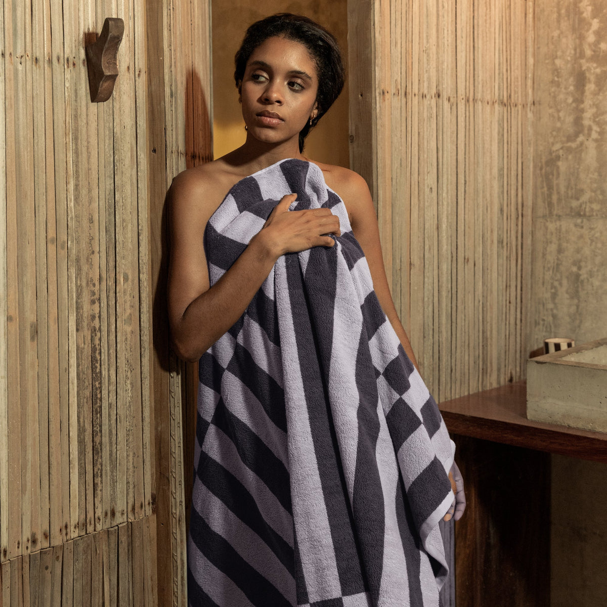 Gray-and-lilac checkered towel held up for drying or wrapping.