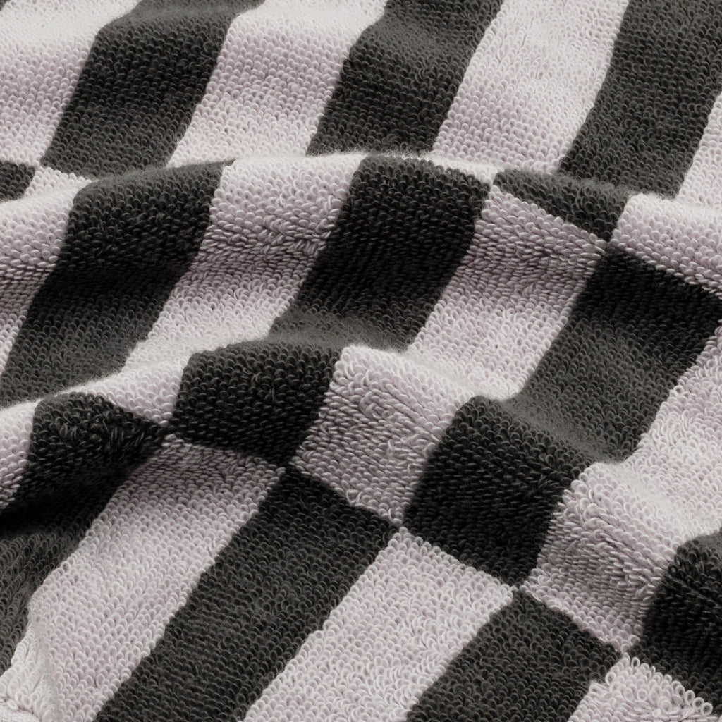 Close-up of charcoal-and-lilac checkered towel fabric with textured loops.