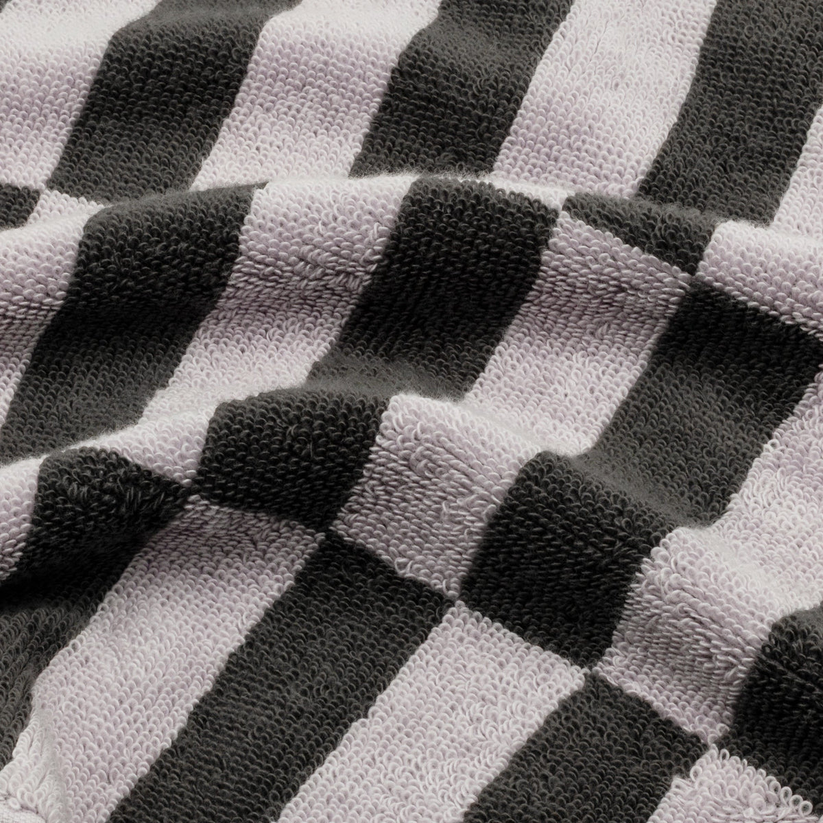 Close-up of charcoal-and-lilac checkered towel fabric with textured loops.