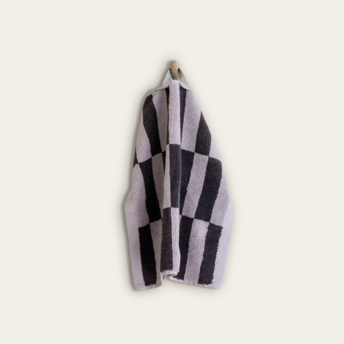 Folded towel with charcoal-and-lilac checkered stripes, hanging on a hook.