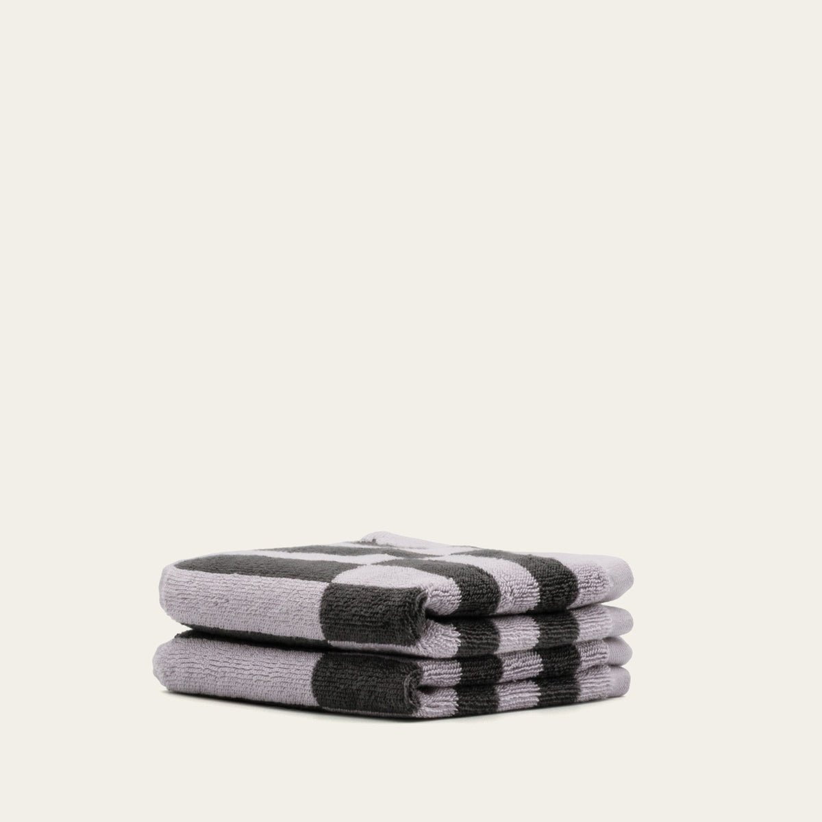 Two folded charcoal-and-lilac checkered towels stacked with visible stripe pattern.