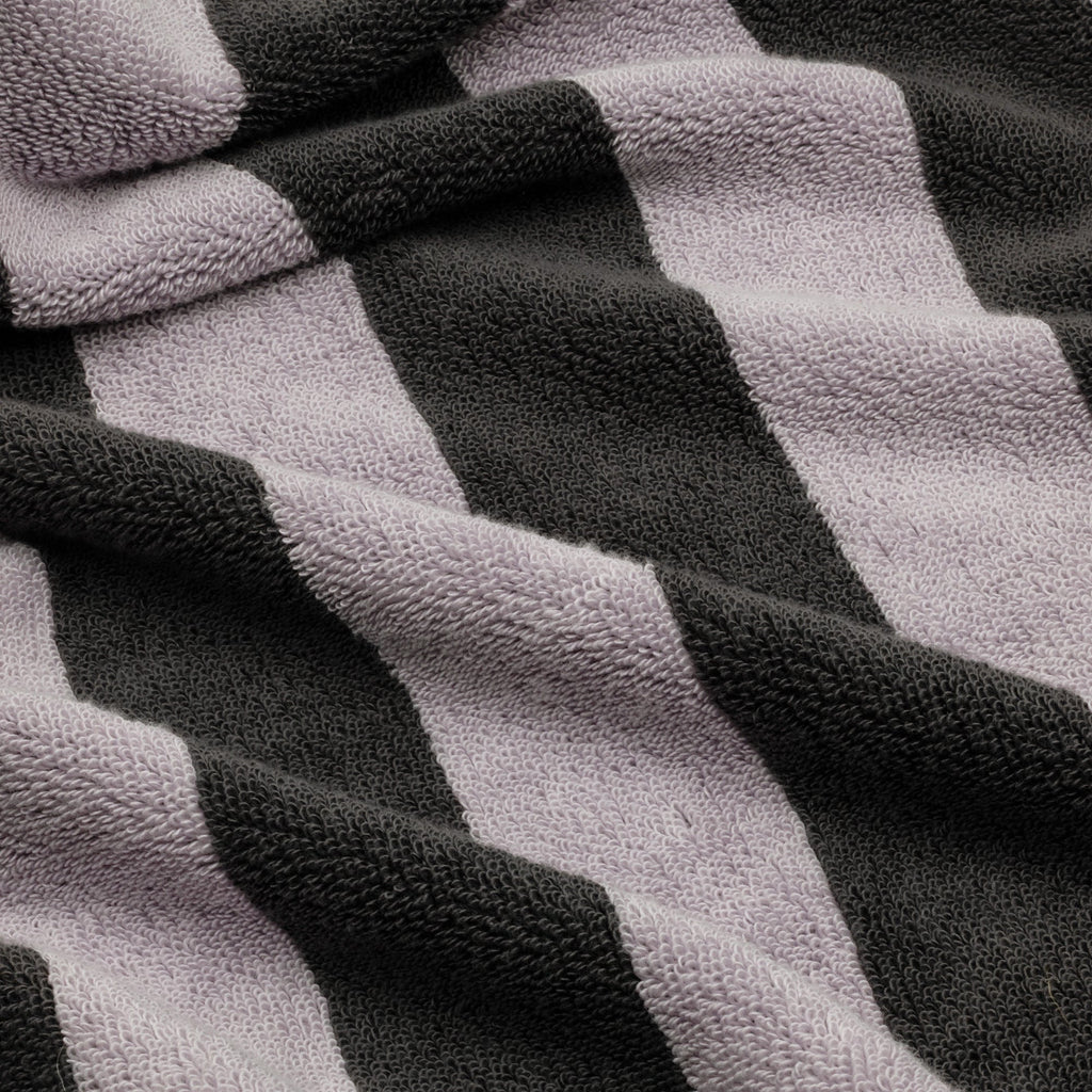Close-up of lilac and charcoal striped cotton towel with textured terry weave.
