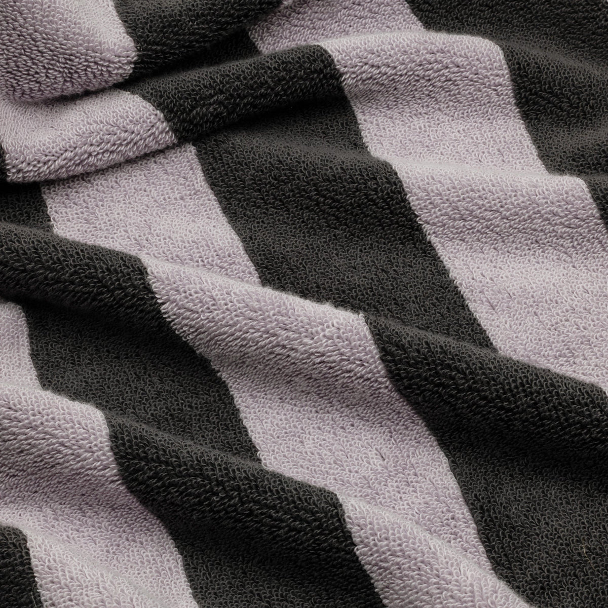 Close-up of lilac and charcoal striped cotton towel with textured terry weave.