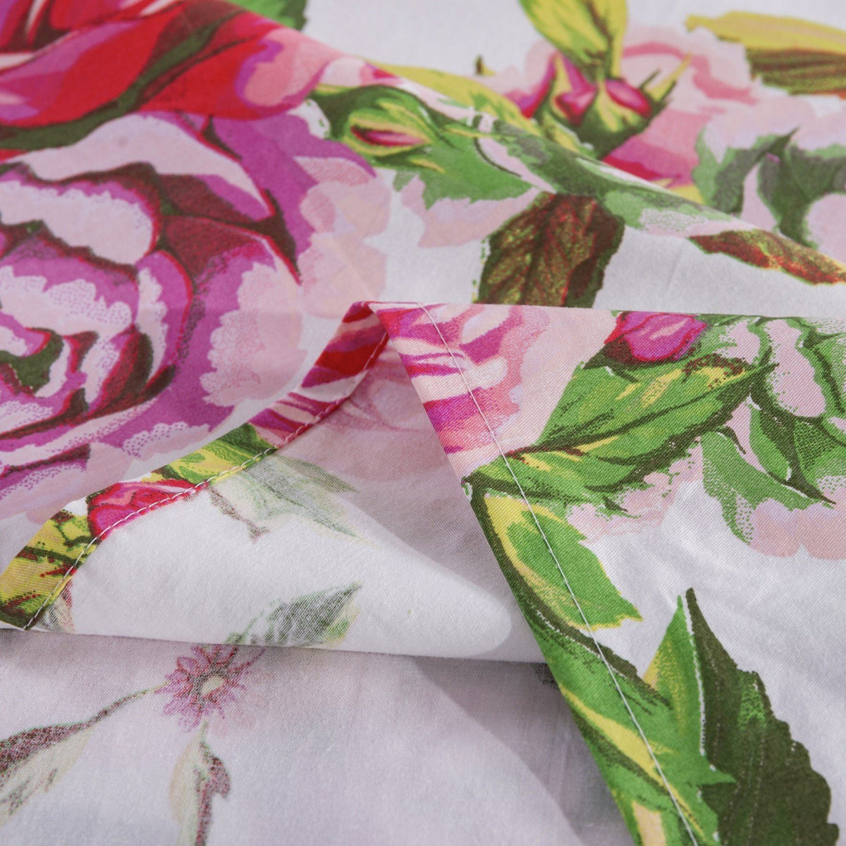 Rose floral fabric fold with pink blossoms and green leaves on a white base