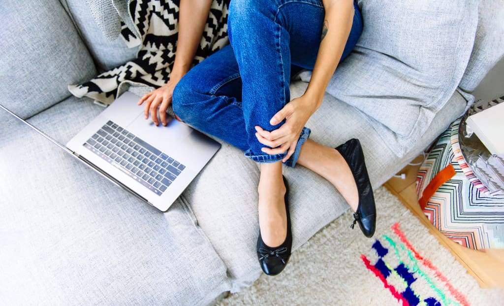 Black ballet flats on model foot with blue jeans