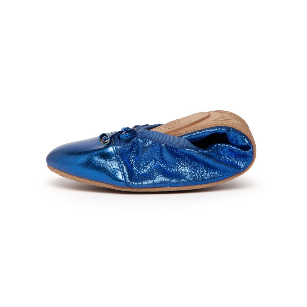 Cobalt blue flats with side tie eyelets and tan underside detail