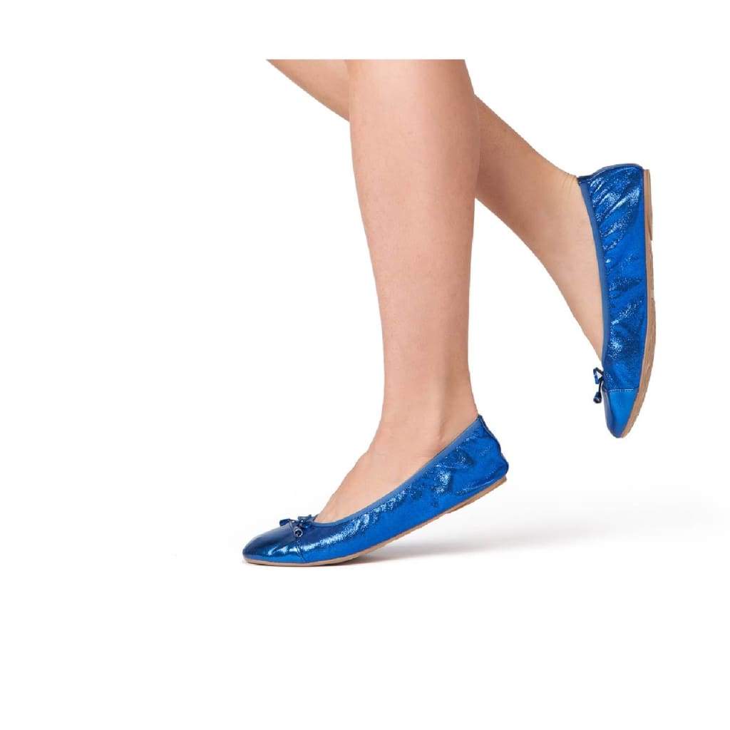 Cobalt blue flats on model’s feet with ribbon lace-up ties