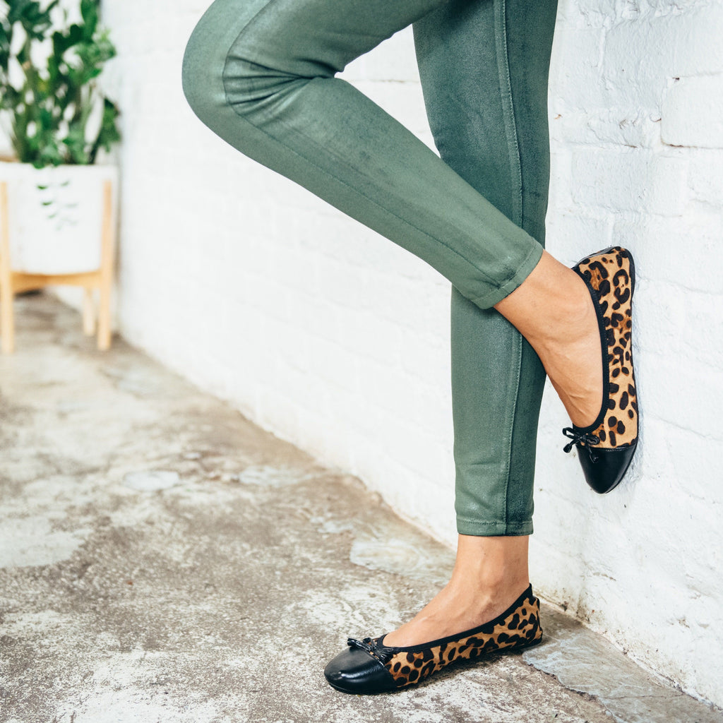 Leopard print flats worn with jeans, featuring black bow laces