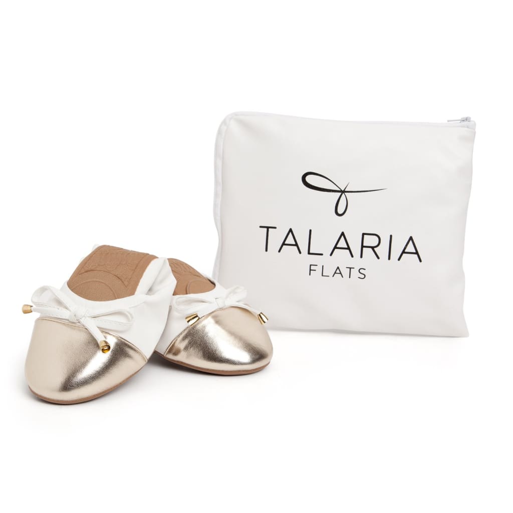 White flats with bow ties and metallic toe cap, shown with Talaria flats dust bag.