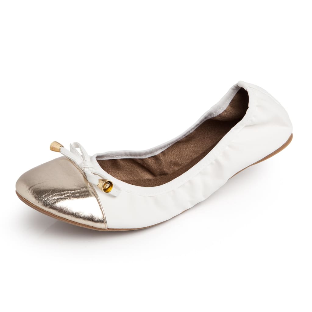 White slip-on flats with metallic toe cap and bow detail, low-profile sole.