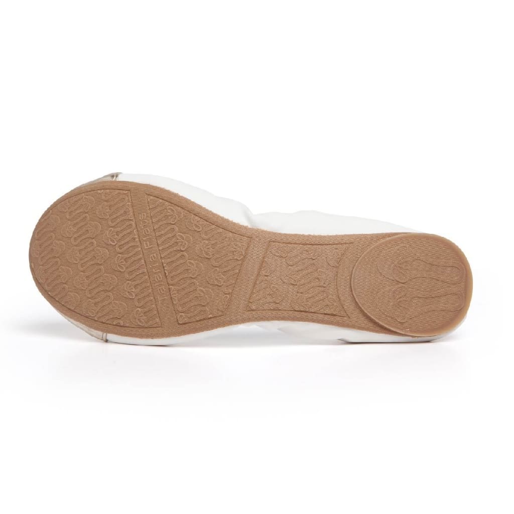 White flats underside with textured tan rubber sole.