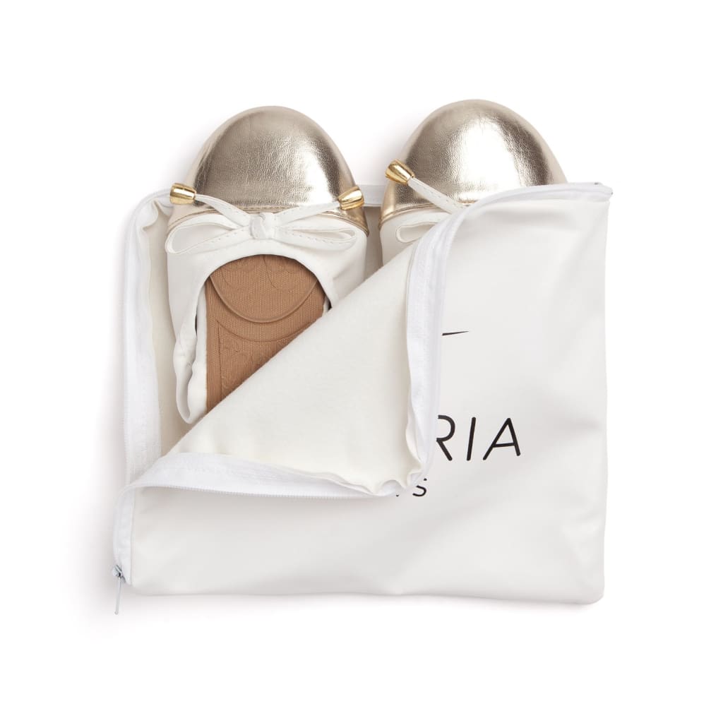 White flats with metallic toe caps, folded in white dust bag.