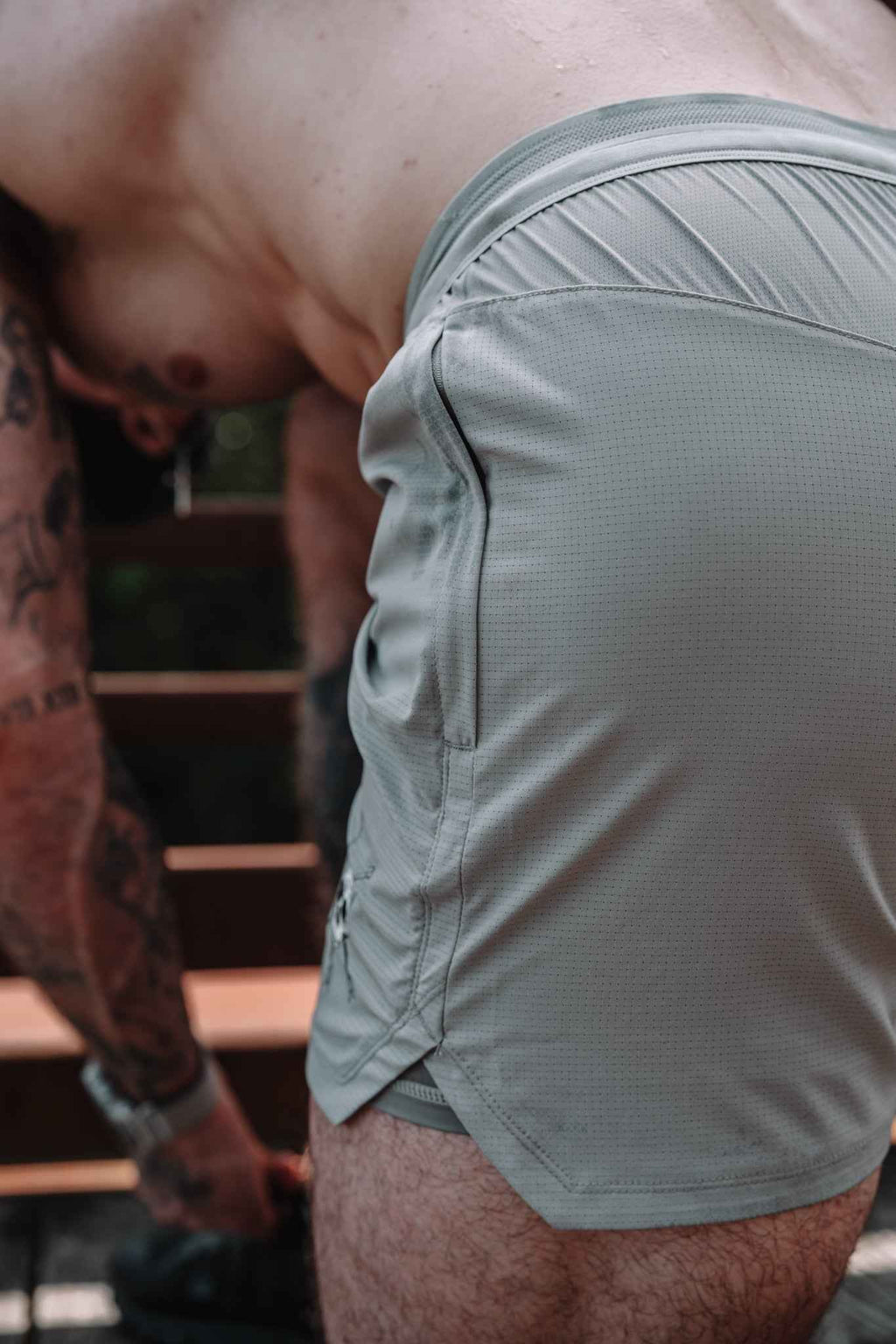 Gray shorts close-up at back panel with elastic waistband and small skull emblem detail.