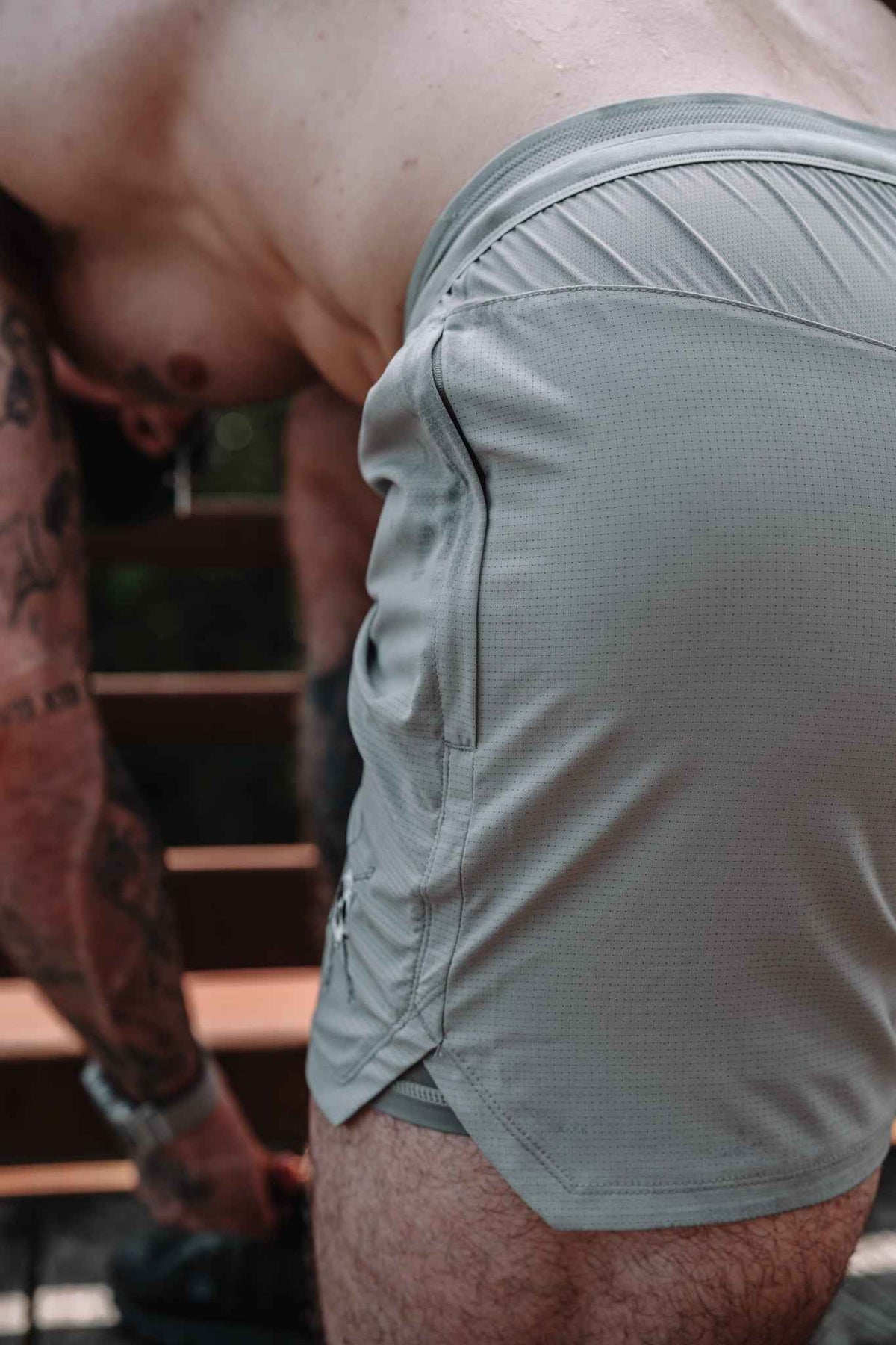 Gray shorts close-up at back panel with elastic waistband and small skull emblem detail.