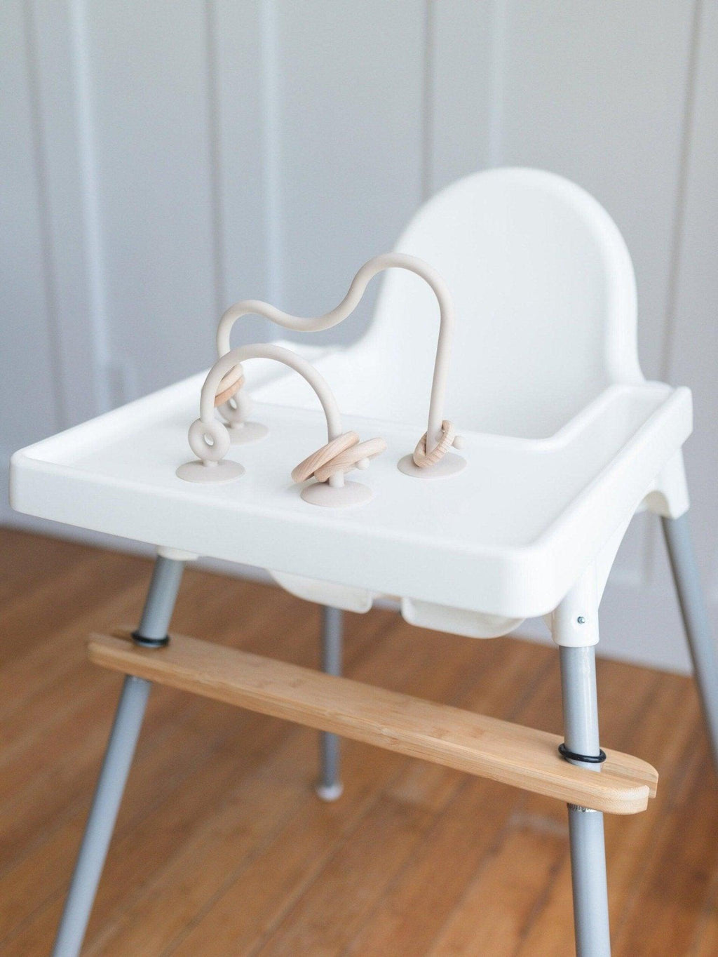 Silicone highchair toy set with cream loops and two dangling ring pieces on tray