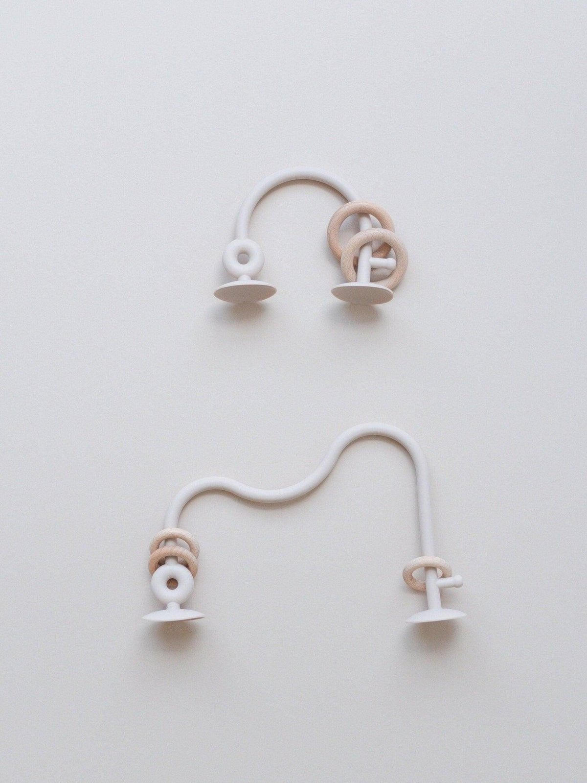 Silicone highchair toy set close-up: cream and white arch loops with ring ends